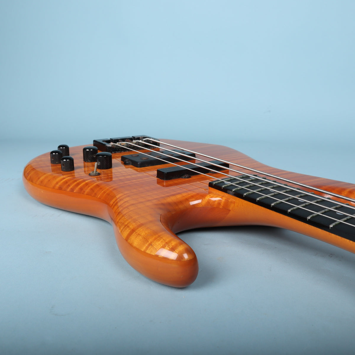 Angled perspective of the bass body highlighting the arched carve and electronics.