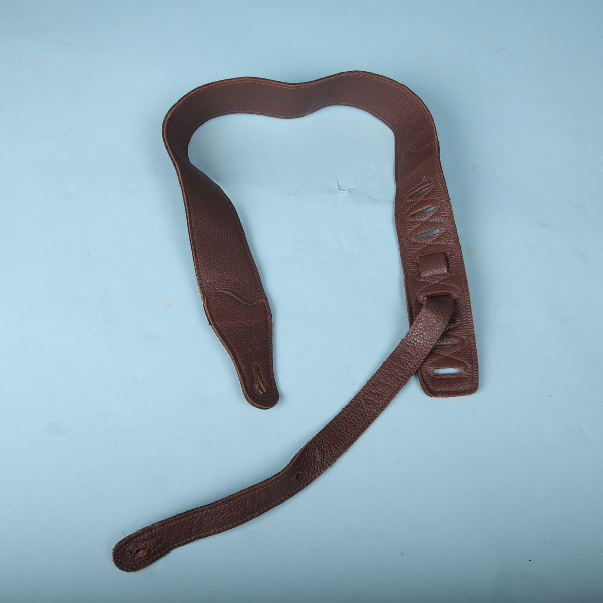 Full view of the Levy's brown leather guitar strap arranged in a loop