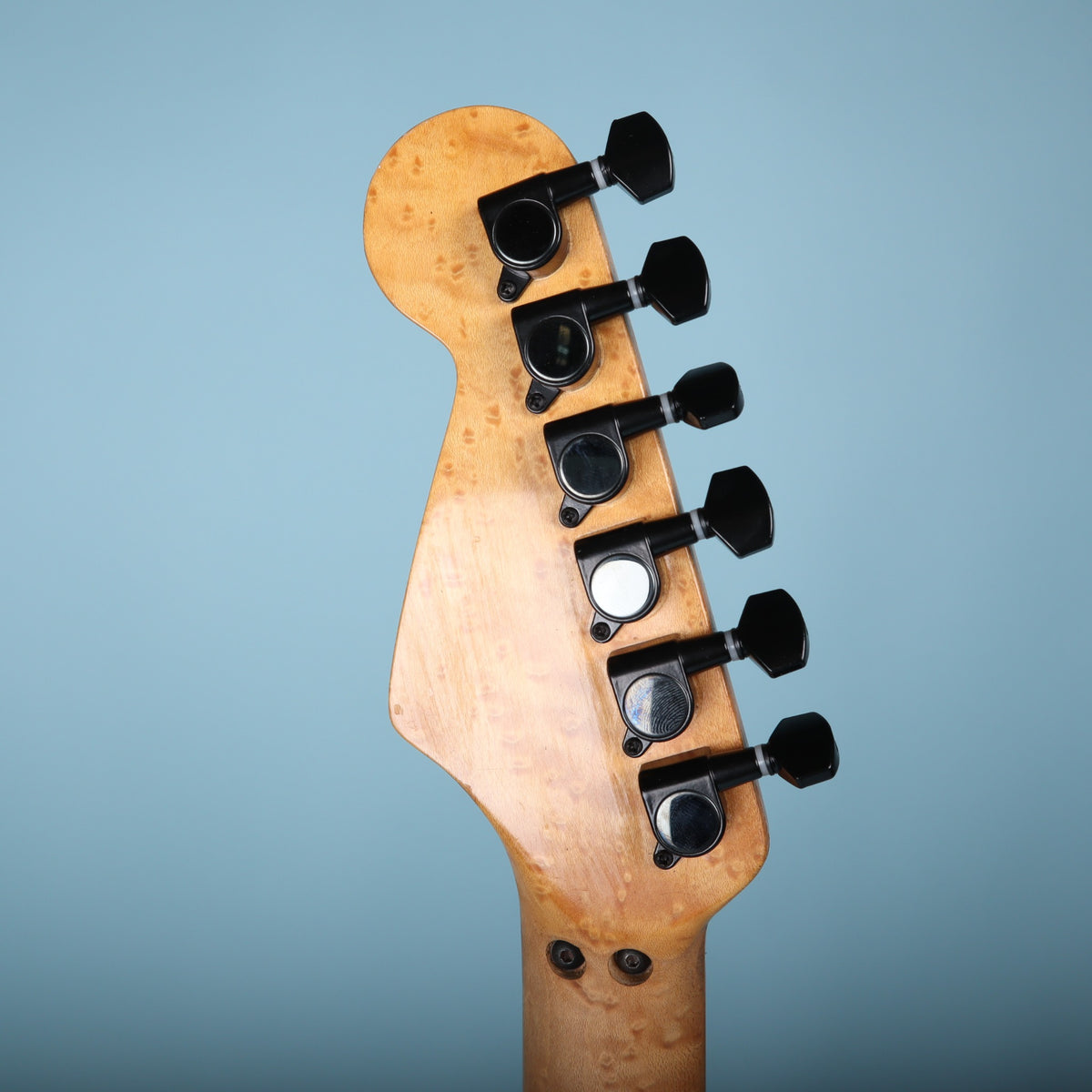 Back of headstock showing six-in-line black tuning machines.