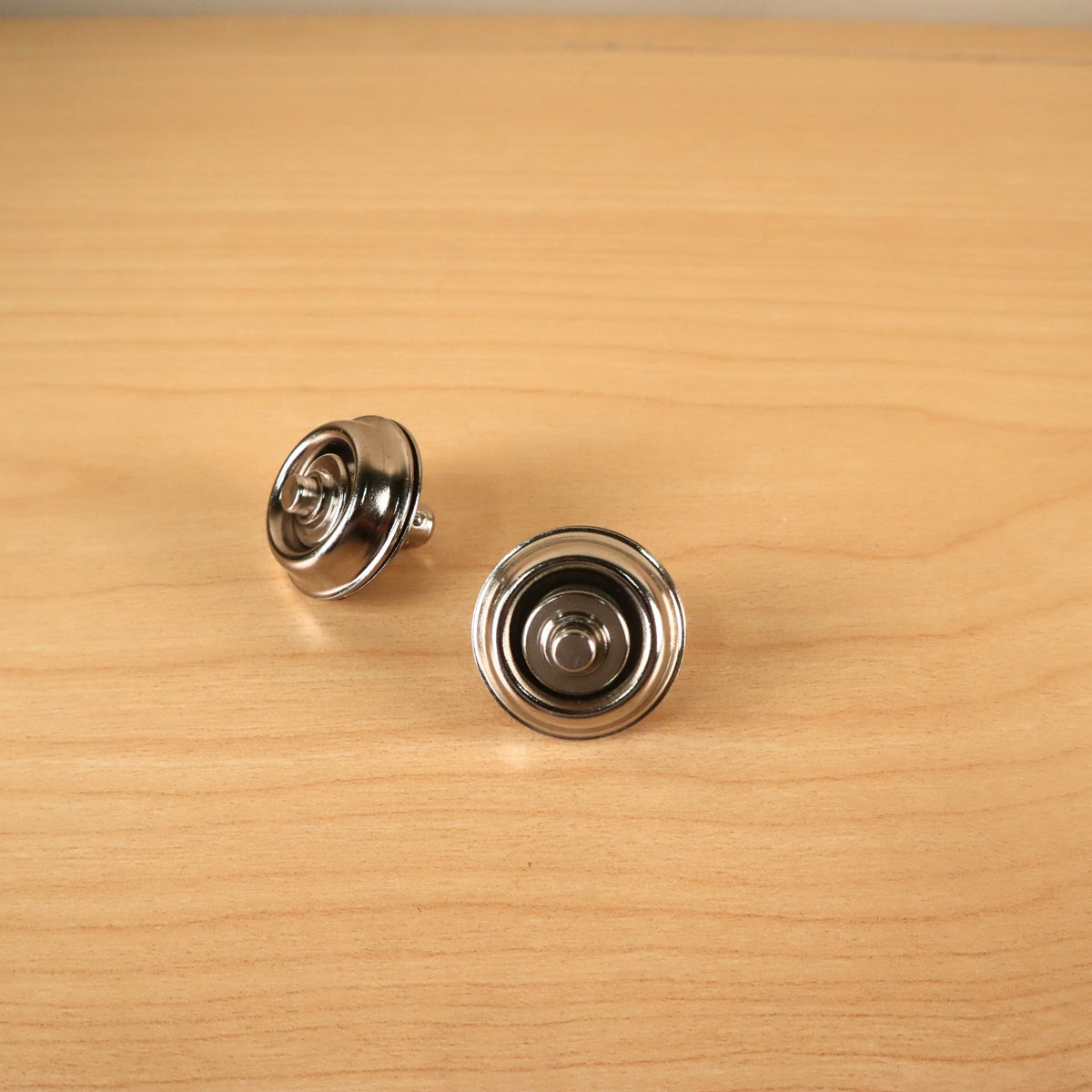 Close-up of two Dunlop Straplok quick-release strap attachments showing the spring-loaded plunger mechanism.