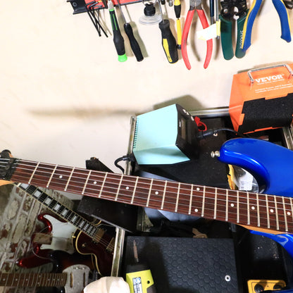 Rosewood fretboard and neck resting on a workbench support