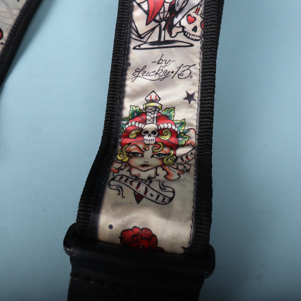 Close-up of Lucky 13 skull and dagger tattoo flash artwork on the strap face