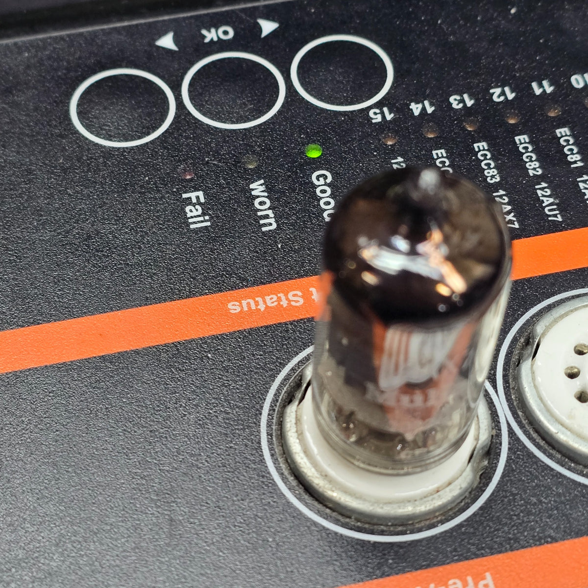 Mullard 12AX7A tube inserted in tube tester showing green Good status indicator lit.